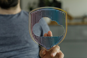 Secure cloud data protection concept. Hand holding a shield with cloud shape symbol. Technology,...
