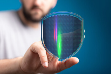 Concept of cybersecurity with a hand holding a glowing digital shield, representing data protection...