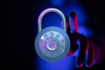 A futuristic padlock with a glowing interface and a hand reaching towards it, symbolizing digital security, data protection and safet