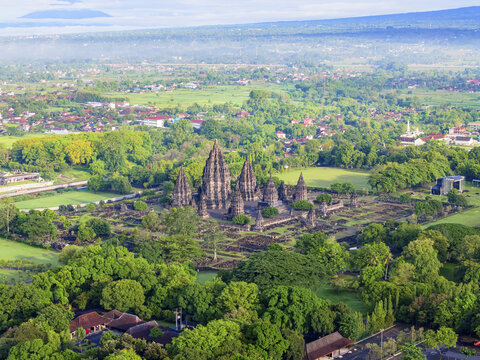 Aerial view of the majestic Prambanan Temple rises amidst a sea of green, a testament to ancient artistry and enduring faith, Yogyakarta, Daerah Istimewa Yogyakarta, Indonesia.