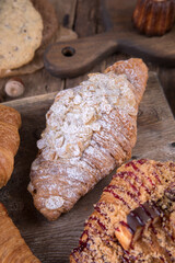 Various types of desserts and pastries on an old wooden background