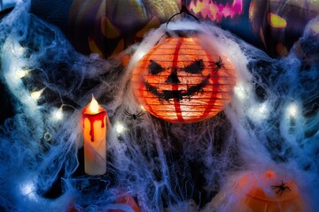 A terrifying Halloween display with a candle and pumpkins.