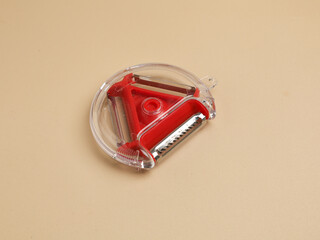 Red vegetable peeler with three different blades, isolated