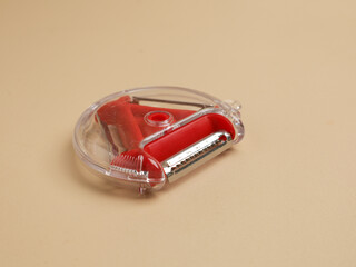Red vegetable peeler with three different blades, isolated