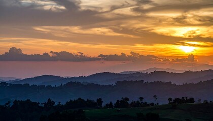 Naklejka premium Mountain ranges fade into distance beneath sunset, a painterly sky above