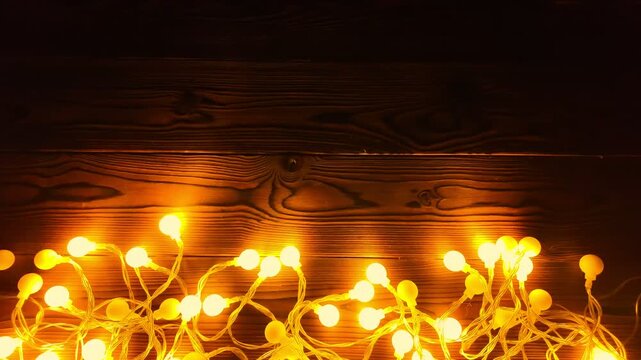 Joyous celebration atmosphere created by glowing garland lights against wood backdrop, evoking feelings of happiness and warmth during holiday season, copy space