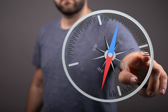 Close up of a man holding a compass concept representing direction, guidance, and choices for the future. Perfect for business, travel, or decis