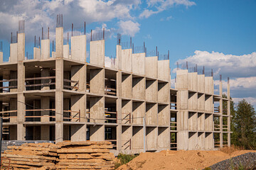 Fototapeta premium Workers at a construction site are busy shaping a new building with concrete and steel