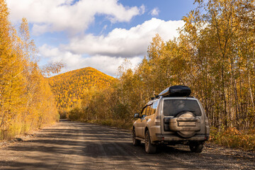 Japanese SUV on scenic autumn road in the forest
