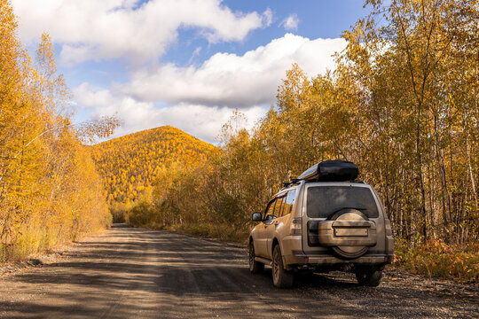 Japanese SUV on scenic autumn road in the forest