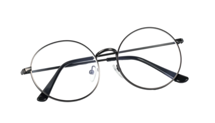 Round metal rimmed prescription eyewear rests isolated against a deep black background