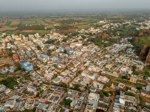 Aerial view of the town nestled amidst rugged terrain, with buildings clustered tightly together, showcasing the unique architecture, Badami, Karnataka, India.