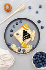 Funny cute sandwich toast bread.Kids childrens baby's dessert healthy breakfast lunch food art like fish with fruits,blueberry,wooden background close up,top view