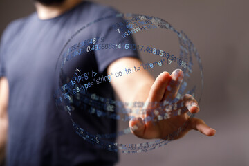 A close-up shot of a man's hand interacting with a digital interface overlaid on a blurred background, representing big data and tech