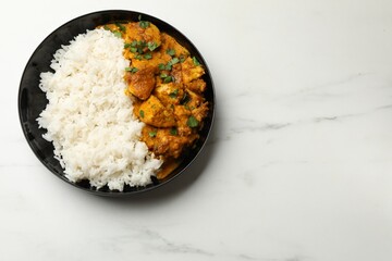 Chicken tikka masala with rice and parsley in bowl on white marble table, top view. Space for text
