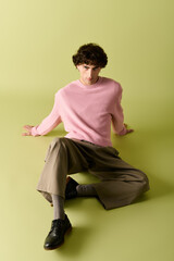 Stylish man poses confidently in soft pastels against a vibrant background