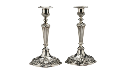 Pair of ornate silver metal candle holders rests against a solid dark background