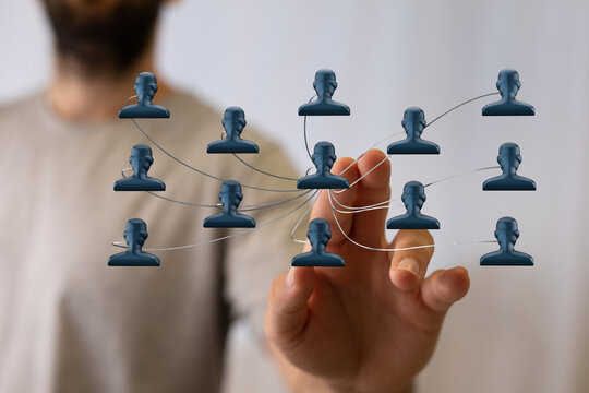 Hand touching network of people symbols, representing connection, communication, and digital technology concepts like teamwork, globalization an