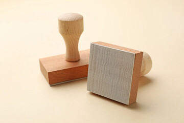Two wooden stamps on beige background, closeup