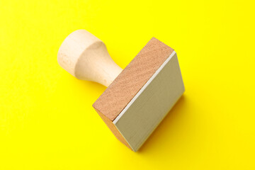 One wooden stamp on yellow background, closeup