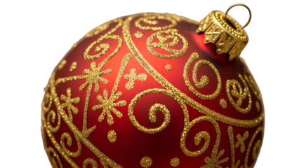 Close up of a deep red holiday decoration adorned with sparkling gold glitter patterns on a dark background