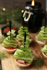 Christmas trees made with cucumber, red caviar, ham and festive decor on table, closeup