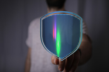 Hand holding a futuristic shield depicting digital data protection, cybersecurity and safe online...