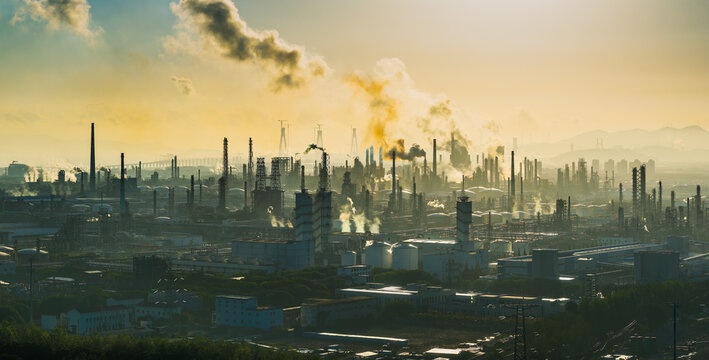 Aerial shot of an oil refinery and chemical plant with smoking chimneys in a large industrial area