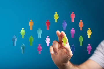 Hand reaching towards a collection of colorful community figures on a blue background, representing workforce diversity and choice.