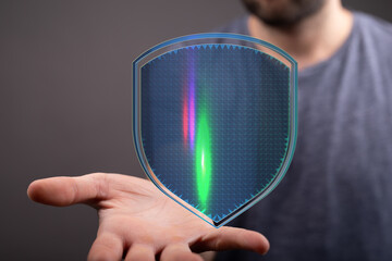 Concept image of a glowing digital shield held in a human hand, representing digital security,...