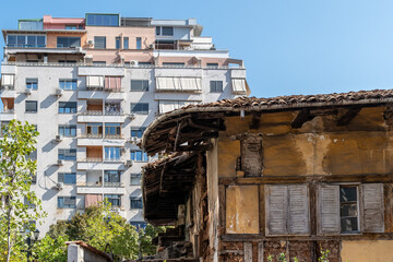 Neuer Wohnblock ragt über verfallenen traditionellen Altbau hinweg, Tirana, Albanien