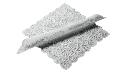 Intricate white lace fabric exhibits delicate floral patterns partially rolled up on a dark background