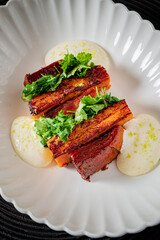 Beautifully plated dish showcases grilled vegetables with creamy sauce and fresh greens on top