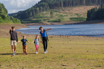 Family strolls by serene Howden reservoir, enjoy nature beauty