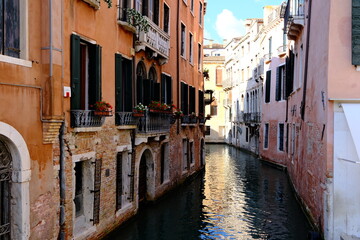 narrow canal in Venice, Italy with old Venetian-style brick buildings