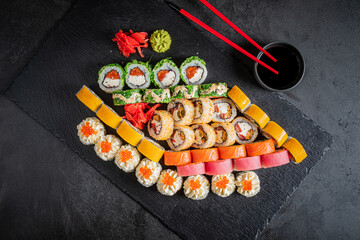 A vibrant assortment of sushi rolls is artfully arranged with garnishes and wasabi, ready to enjoy
