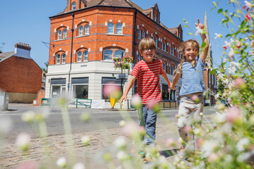 Cute kids travelers hold hands in a small town of Farnham, UK
