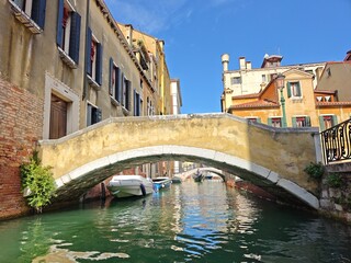 Stone bridge over a small canal in Venice with buildings