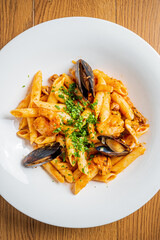 Penne pasta with fresh seafood and herbs creates a warm, inviting dining vibe