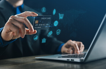 Fototapeta premium A businessman using a credit card for online payment on a laptop, symbolizing digital banking, fintech innovation, secure transaction, and modern e-commerce technology for global financial business.