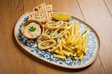 A savory spread of fresh pita, golden fries, and smooth hummus makes a perfect meal