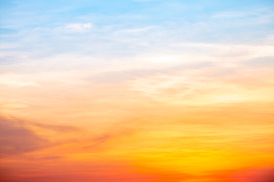 Sunset or sunrise sky with a vibrant gradient of orange, gold, and soft blue. Clear atmosphere with wispy clouds. Peaceful, natural light background. hope, freedom, new day and inspirational Concepts