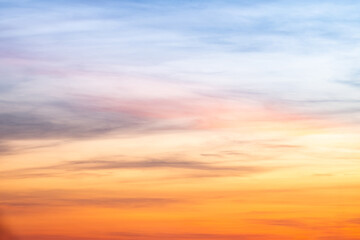 Sunset or sunrise sky with a vibrant gradient of orange, gold, and soft blue. Clear atmosphere with wispy clouds. Peaceful, natural light background. hope, freedom, new day and inspirational Concepts