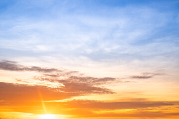 Sunset or sunrise sky with a vibrant gradient of orange, gold, and soft blue. Clear atmosphere with wispy clouds. Peaceful, natural light background. hope, freedom, new day and inspirational Concepts