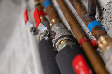 Gros plan sur une vanne d'eau avec des tuyaux en cuivre lors des travaux de plomberie.