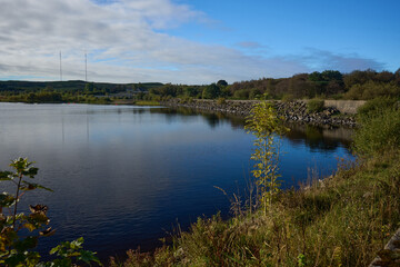 Autumn light bathes Hillend Loch, Caldercruix, as calm water mirrors the changing hills.