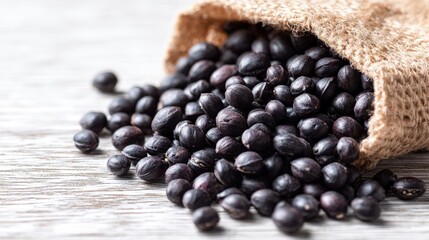 Black Beans Poured From Burlap Bag On White Wood