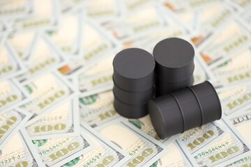 Barrels of oil on bills of American dollars. purchase, sale of oil concept close up