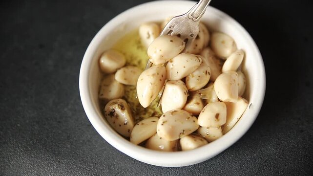 Garlic slices in flavored oil roasted garlic slice in oil fast food natural tasty appetizer fresh delicious gourmet food background on the table rustic top view copy space vegetarian or vegan food