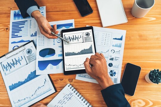 Busy analyst team in office analyzing financial data analysis by tablet. Entity